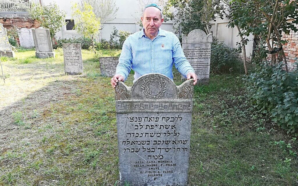 Giuseppe Minera aux abords d'une stèle dans le cimetière juif d'Ostiano, en Italie (Crédit : Giovanni Vigna/ Times of Israel)