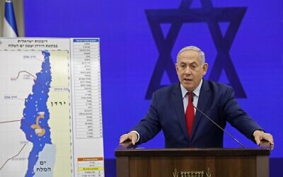 Le Premier ministre Benjamin Netanyahu s'exprime devant une carte de la vallée du Jourdain alors qu'il promet d'y étendre la souveraineté israélienne ainsi que dans la zone nord de la mer Morte à Ramat Gan, le 10 septembre 2019. 
(Crédit : Menahem KAHANA / AFP)
