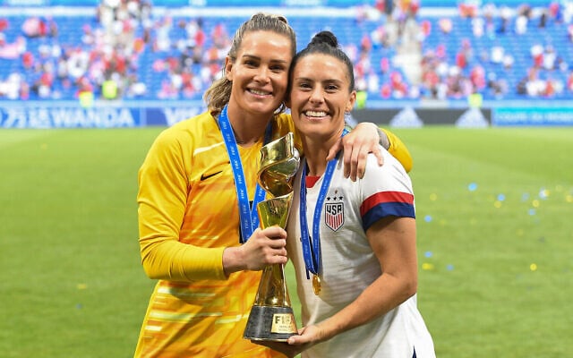 Les joueuses de l'équipe américaine de football Ashlyn Harris, à gauche, et  Ali Krieger posent avec le trophée de la Coupe du monde après avoir remporté le tournoi au Stade de Lyon, à Lyon, en France, le 7 juillet 2019 (Crédit :  Brad Smith/isiphotos.com/Getty Images)
