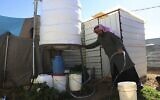 Un Syrien remplit un seau d'eau à l'intérieur de Zaatari, le plus grand camp de réfugiés syriens à Mafraq, Jordanie, le 3 février 2019. (AP Photo/Raad Adayleh)