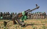 Des combattants des brigades Ezzedine Al-Qassam, aile militaire du groupe terroriste du Hamas, derrière un fusil automatique à Khan Younès, dans le sud de la bande de Gaza, le 11 novembre 2019 (Crédit : Said Khatib/AFP)