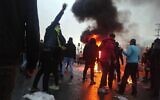 Des manifestants iraniens se rassemblent autour d'un feu lors d'une manifestation contre l'augmentation du prix de l'essence dans la capitale Téhéran, le 16 novembre 2019. (Crédit : AFP)