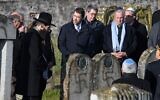 Le ministre français de l'Intérieur, Christophe Castaner (C) et le président du Conseil national des Archives françaises, Jean-Louis Debre (2ndD), visitent le cimetière juif de Westhoffen, le 4 décembre 2019, dans l'est de la France, où 107 tombes ont été découvertes vandalisées avec des croix gammées et des inscriptions antisémites. (Crédit : Patrick HERTZOG / AFP)