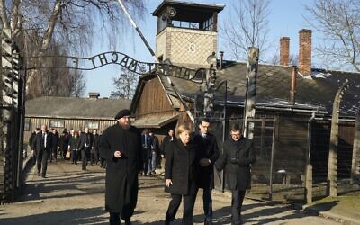 La chancelière allemande Angela Merkel accompagnée du Premier ministre Mateusz Morawiecki et le directeur du musée d'Auschwitz-Birkenau Piotr Cywinski, au camp de concentrationd'Auschwitz-Birkenau, le 6 décembre 2019. (Crédit : SKARZYNSKI / AFP)