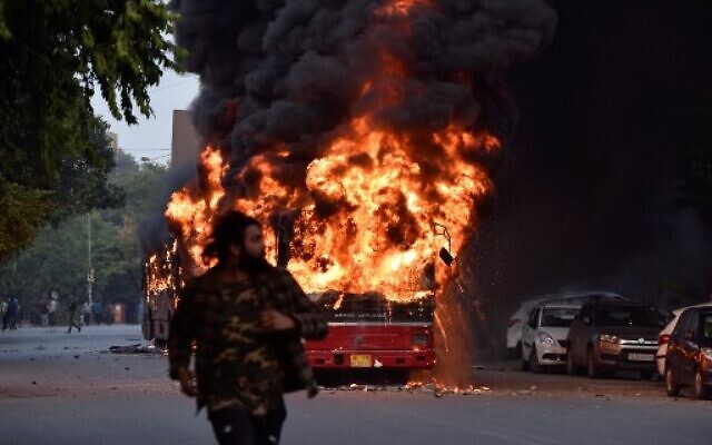 Un autobus en feu à la suite d'une manifestation contre le projet de loi du gouvernement indien sur la citoyenneté à New Delhi le 15 décembre 2019. (Crédit : STR / AFP) Un autobus en feu à la suite d'une manifestation contre le projet de loi du gouvernement indien sur la citoyenneté à New Delhi le 15 décembre 2019. (Crédit : STR / AFP)