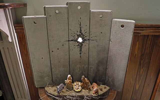 Une nouvelle oeuvre de Noël, "La cicatrice de Bethléem", réalisée par l'artiste britannique Banksy, exposée au Walled-Off Hotel à Bethléem, en Cisjordanie, le 20 décembre 2019 (Crédit : AHMAD GHARABLI / AFP) Une nouvelle oeuvre de Noël, "La cicatrice de Bethléem", réalisée par l'artiste britannique Banksy, exposée au Walled-Off Hotel à Bethléem, en Cisjordanie, le 20 décembre 2019 (Crédit : AHMAD GHARABLI / AFP)