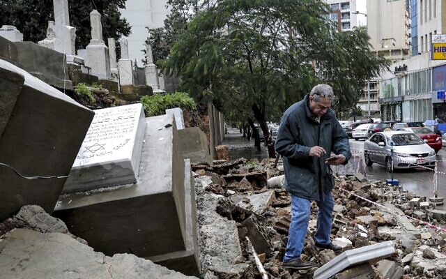 Un homme inspecte des tombes endommagées par le mauvais temps lors d'une tempête hivernale au cimetière juif de la capitale libanaise, Beyrouth, le 26 décembre 2019. (Crédit : ANWAR AMRO / AFP) Un homme inspecte des tombes endommagées par le mauvais temps lors d'une tempête hivernale au cimetière juif de la capitale libanaise, Beyrouth, le 26 décembre 2019. (Crédit : ANWAR AMRO / AFP)