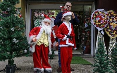 Un commerçant palestinien habille des mannequins en père noël aux abords de son magasin de Gaza City, le 25 décembre 2017 (Crédit : AFP Photo/Mohammed Abed)