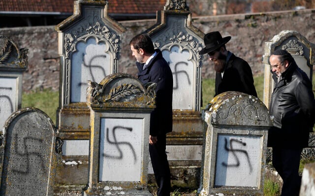 Le ministre français de l'Intérieur Christophe Castaner, au centre, suivi du rabbin en chef de Strasbourg Harold Abraham Weill, deuxième à droite, marche au milieu des tombes vandalisées dans le cimetière juif de Westhoffen, à l'ouest de la ville de Strasbourg, dans l'est de la France, le mercredi 4 décembre 2019. (Crédit : AP / Jean-François Badias) Le ministre français de l'Intérieur Christophe Castaner, au centre, suivi du rabbin en chef de Strasbourg Harold Abraham Weill, deuxième à droite, marche au milieu des tombes vandalisées dans le cimetière juif de Westhoffen, à l'ouest de la ville de Strasbourg, dans l'est de la France, le mercredi 4 décembre 2019. (Crédit : AP / Jean-François Badias)