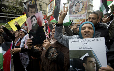 Des proches de Palestiniens détenus dans des prisons israéliennes brandissent leur portrait lors d'une manifestation pour marquer la "Journée des prisonniers" à Ramallah, en Cisjordanie, le mercredi 7 avril 2019. (AP Photo/Majdi Mohammed)