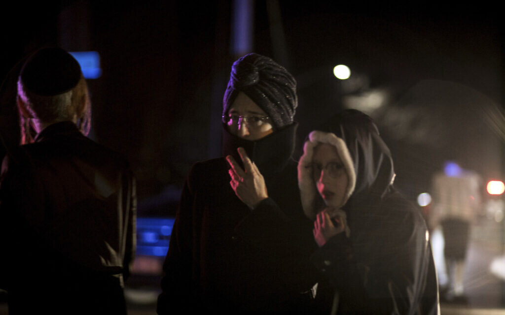 Des passants, dont des résidents juifs orthodoxes, se tiennent au coin de Forshay Road à Monsey, New York, le 29 décembre 2019, en bas de la rue où s'est produit un massacre à coups de couteau la veille, lors d'une célébration de Hanoukka. (Crédit : AP Photo/Allyse Pulliam) Des passants, dont des résidents juifs orthodoxes, se tiennent au coin de Forshay Road à Monsey, New York, le 29 décembre 2019, en bas de la rue où s'est produit un massacre à coups de couteau la veille, lors d'une célébration de Hanoukka. (Crédit : AP Photo/Allyse Pulliam)