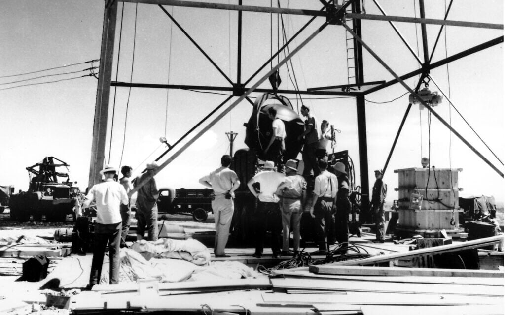 Des scientifiques et des ouvriers construisant la première bombe atomique au monde qui est montée dans une tour de 30 mètres de haut à Trinity, le site d'essai de la bombe, dans le désert près d'Alamagordo, au Nouveau-Mexique, en juillet 1945. (Crédit : AP Photo)