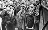 Les enfants de Drancy, le 31 décembre 1945, attendent patiemment que les travailleurs de la Croix-Rouge américaine se préparent à distribuer de nouvelles chaussures pour remplacer les chaussures usées et déchirées qu'ils portaient. (Crédit : AP)