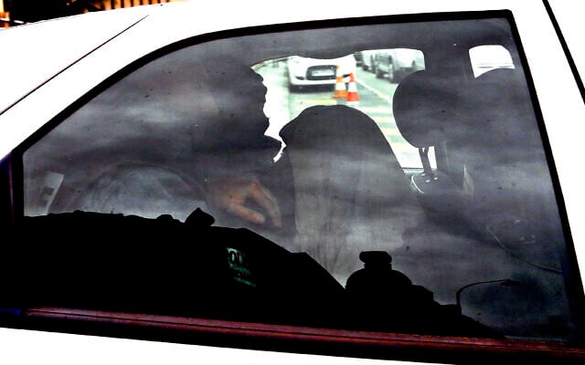 Moussa Coulibaly, à droite, qui a attaqué trois soldats en faction devant un centre communautaire juif à Nice le 3 février dernier, quitte le commissariat de Nice dans une voiture de police, le 5 février 2015. (Crédit : AP / Lionel Cironneau)