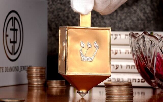 La toupie de 70 000 $ en or jaune de 18 carats et incrustée de 220 diamants ronds et brillants créée par Estate Diamond Jewelry à New York, nommée la toupie la plus précieuse du monde par le Guinness World Records. (Crédit : Estate Diamond Jewelry via JTA) La toupie de 70 000 $ en or jaune de 18 carats et incrustée de 220 diamants ronds et brillants créée par Estate Diamond Jewelry à New York, nommée la toupie la plus précieuse du monde par le Guinness World Records. (Crédit : Estate Diamond Jewelry via JTA)