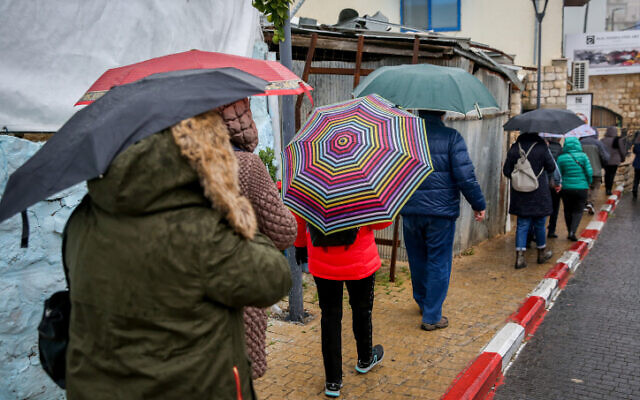 Les gens marchent sous la pluie à Tsfat, le 9 décembre 2019. (Crédit : David Cohen/Flash90)