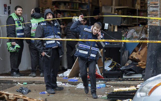 Des premiers intervenants nettoient la scène de la tuerie qui a fait plusieurs victimes dans une épicerie casher, le mercredi 11 décembre 2019, à Jersey City, (New Jersey). (AP Photo/Kevin Hagen) Des premiers intervenants nettoient la scène de la tuerie qui a fait plusieurs victimes dans une épicerie casher, le mercredi 11 décembre 2019, à Jersey City, (New Jersey). (AP Photo/Kevin Hagen)