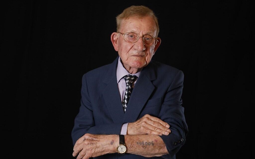 Le survivant de la Shoah Shmuel Blumenfeld, montre sa matricule 108006 , à son domicile de Bat Yam, le 28 novembre 2019. (Crédit : MENAHEM KAHANA / AFP)