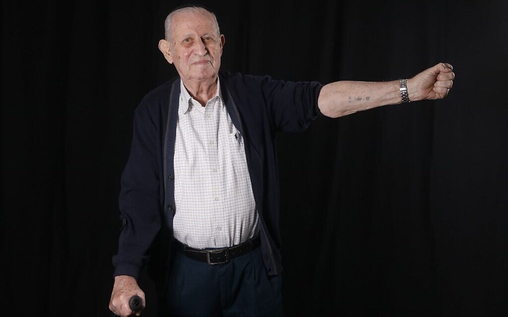Le survivant de la Shoah Avraham Gershon Binet, 81 ans,  montre son matricule 14005, à son domicile de Bnei Brak le 8 décembre 2019. (Crédit : MENAHEM KAHANA / AFP)