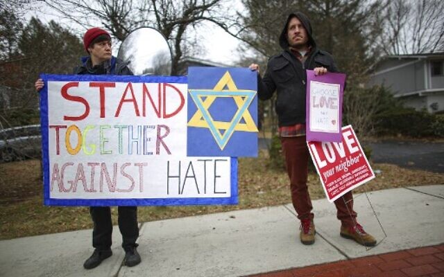 Des manifestants arborent des panneaux de soutien près de la maison du Rabbin Chaim Rottenberg le 29 décembre 2019 à Monsey, New York. (Photo de Kena Betancur / AFP) Des manifestants arborent des panneaux de soutien près de la maison du Rabbin Chaim Rottenberg le 29 décembre 2019 à Monsey, New York. (Photo de Kena Betancur / AFP)