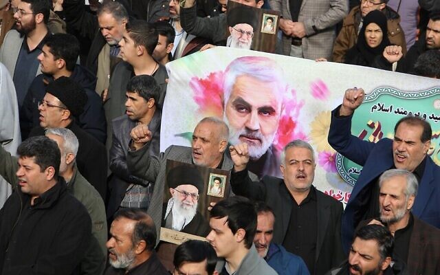 Des Iraniens défilent avec une bannière portant la photo du général Qassem Soleimani, chef des forces al-Quads, lors d'une manifestation après la mort de ce dernier organisée à Téhéran, le 3 janvier 2020 (Crédit : Atta Kenare/AFP) Des Iraniens défilent avec une bannière portant la photo du général Qassem Soleimani, chef des forces al-Quads, lors d'une manifestation après la mort de ce dernier organisée à Téhéran, le 3 janvier 2020 (Crédit : Atta Kenare/AFP)