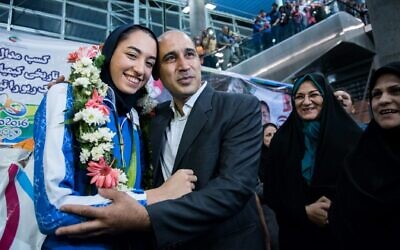 Kimia Alizadeh, la première Iranienne à avoir remporté une médaille olympique, est accueillie par son père Keivan Alizadeh (à droite) à son arrivée à l'aéroport international Imam Khomeini de la capitale Téhéran, le 26 août 2016. (Crédit : Peyman / ISNA / AFP)