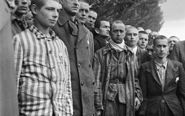 Sur cette photographie prise le 29 avril 1945, des prisonniers français observent une minute de silence, lors de la libération du camp de concentration nazi de Dachau, près de Munich, par les troupes alliées. (Crédit : Eric Schwab / AFP)