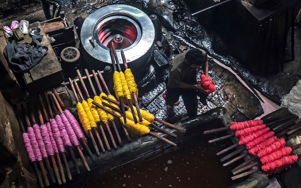 Des ouvriers teignent des fils dans un atelier traditionnel de teinture à la main dans le quartier séculaire de Darb al-Ahmar, au Caire, la capitale égyptienne, le 21 janvier 2020. (Crédit : Khaled DESOUKI / AFP)