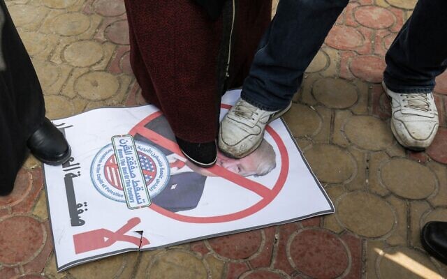Des manifestants palestiniens foulent aux pieds une affiche montrant le visage du président américain Donald Trump lors d'une manifestation contre l'annonce prévue d'un plan de paix, à Rafah, dans le sud de la bande de Gaza, le 28 janvier 2020. (Photo par SAID KHATIB / AFP)