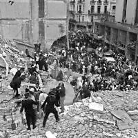 Des pompiers et des policiers recherchant des blessés après l'explosion d'une bombe à l'Association mutuelle israélite argentine (AMIA en espagnol), à Buenos Aires, le 18 juillet 1994. (Crédit : Ali Burafi/AFP/Getty Images via JTA)