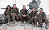 Le chef de forces blindés de l'armée israélienne, le général Guy Hasson, au centre, prend la pose sur un tank avec la première femme commandant de l'armée, qui a terminé sa formation , le 28 juin 2018. (Tsahal)