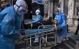 Des personnels médicaux en habit de protection transportent un patient depuis son appartement soupçonné d'être atteint par le virus à Wuhan, le 30 janvier 2020 (Crédit : Hector RETAMAL / AFP)