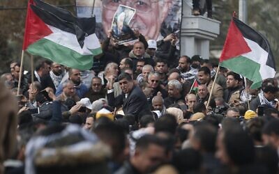 Des manifestants palestiniens agitent des drapeaux lors d'une manifestation en faveur du président Mahmoud Abbas (portrait) et contre une proposition de paix négociée par les Etats-Unis à Gaza City, 11 février 202. (Crédit : MAHMUD HAMS / AFP)