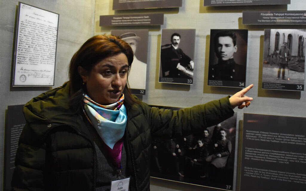 La guide touristique Aygün Agamirzayeva, parlant anglais, explique un panneau historique au complexe commémoratif du génocide de Quba. (Larry Luxner/ Times of Israel)
