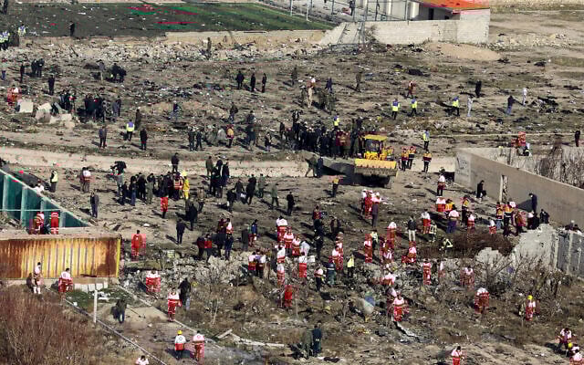 Un bulldozer vu en train de travailler pendant que les secours fouillent la scène où un avion ukrainien s'est écrasé à Shahedshahr, au sud-ouest de la capitale Téhéran, en Iran, le 8 janvier 2020. (Crédit : Ebrahim Noroozi/AP) Un bulldozer vu en train de travailler pendant que les secours fouillent la scène où un avion ukrainien s'est écrasé à Shahedshahr, au sud-ouest de la capitale Téhéran, en Iran, le 8 janvier 2020. (Crédit : Ebrahim Noroozi/AP)