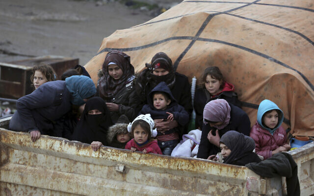 Des Syriens à l'arrière d'un camion fuient l'avancée des forces gouvernementales dans la province d'Idlib, en Syrie, vers la frontière turque, le 30 janvier 2020 (Crédit : Ghaith Alsayed/AP) Des Syriens à l'arrière d'un camion fuient l'avancée des forces gouvernementales dans la province d'Idlib, en Syrie, vers la frontière turque, le 30 janvier 2020 (Crédit : Ghaith Alsayed/AP)