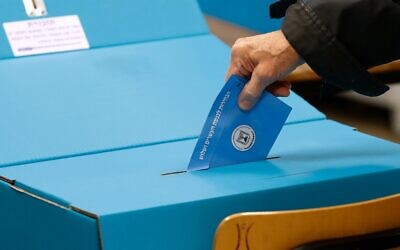 Un bulletin de vote glissé dans l'urne lors des élections nationales du 2 mars 2020. (Crédit : Emmanuel DUNAND / AFP)