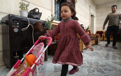 Sur cette photo prise le 19 février 2020, le père syrien Abdullah al-Mohammed marche derrière sa fille de trois ans Salwa dans leur maison à Sarmada, une ville dans la dernière poche rebelle de la province d'Idleb en Syrie. (Photo par Abdulaziz KETAZ / AFP)