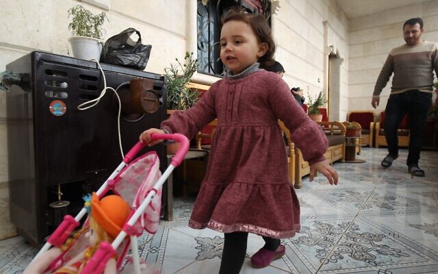 Sur cette photo prise le 19 février 2020, le père syrien Abdullah al-Mohammed marche derrière sa fille de trois ans Salwa dans leur maison à Sarmada, une ville dans la dernière poche rebelle de la province d'Idleb en Syrie. (Photo par Abdulaziz KETAZ / AFP)