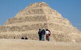 Des visiteurs observent la pyramide de Djoser dans la nécropole égyptienne de Saqqara, au sud de la capitale du Caire, le 5 mars 2020. (Photo par Mohamed el-Shahed / AFP)