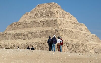 Des visiteurs observent la pyramide de Djoser dans la nécropole égyptienne de Saqqara, au sud de la capitale du Caire, le 5 mars 2020. (Photo par Mohamed el-Shahed / AFP)