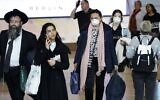 Des passagers portant des masques de protection dans le hall d'arrivées de l'aéroport international Ben Gurion près de Tel Aviv, le 10 mars 2020. (Crédit : Jack Guez/AFP)