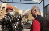 Un membre de la sécurité libanaise vérifie la température d'un visiteur à l'entrée du Sérail gouvernement dans la ville du sud de Saida, le 11 mars 2020, par prévention contre la nouvelle épidémie de coronavirus. (Photo par Mahmoud ZAYYAT / AFP)