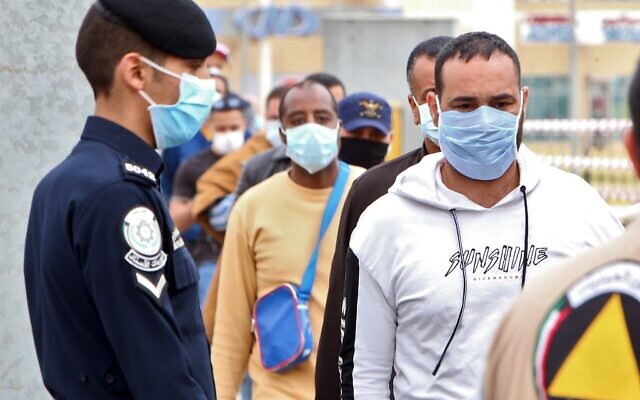 Des travailleurs expatriés de retour d'Egypte, de Syrie et du Liban arrivent au ministère de la Santé, dans la zone de confinement et de contrôle en pleine pandémie du COVID-19, à Koweït City, le 15 mars 2020. (Crédit :  YASSER AL-ZAYYAT / AFP)