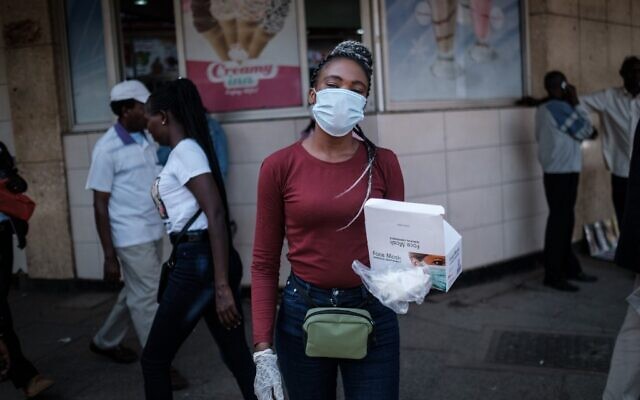 Une femme vend des masques pour environ 2 dollars l'unité dans une rue du centre-ville de Nairobi, au Kenya, le 16 mars 2020. (Photo par Yasuyoshi CHIBA / AFP) Une femme vend des masques pour environ 2 dollars l'unité dans une rue du centre-ville de Nairobi, au Kenya, le 16 mars 2020. (Photo par Yasuyoshi CHIBA / AFP)