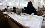 Une femme yéménite fabrique des masques dans une usine textile de la capitale Sanaa, le 16 mars 2020, en pleine pandémie de coronavirus. (Crédit :  Mohammed HUWAIS / AFP)