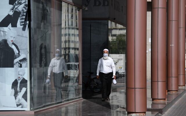 Un homme portant un masque de protection dans une rue de Dubaï, aux Emirats arabes unis, le 18 mars 2020. (Crédit : KARIM SAHIB / AFP) Un homme portant un masque de protection dans une rue de Dubaï, aux Emirats arabes unis, le 18 mars 2020. (Crédit : KARIM SAHIB / AFP)