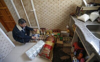 Mustafa al-Khatib, un Palestinien de 51 ans, trie des denrées alimentaires dans la cuisine de sa maison à Gaza City, le 18 mars 2020, en pleine pandémie de coronavirus. (Crédit :  Mohammed ABED / AFP)