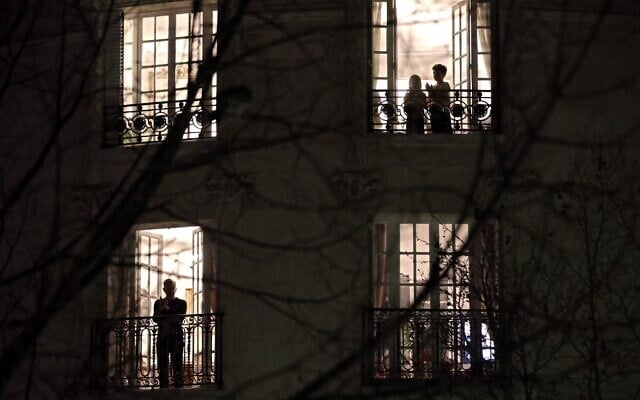 Des Parisiens applaudissent les travailleurs de santé depuis leur balcon à 20h, à Paris, le 18 mars 2020. (Crédit : THOMAS COEX / AFP) Des Parisiens applaudissent les travailleurs de santé depuis leur balcon à 20h, à Paris, le 18 mars 2020. (Crédit : THOMAS COEX / AFP)