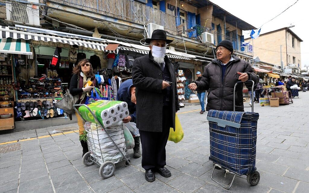 Un juif ultra-orthodoxe portant un masque au marché Mahane Yehuda de Jérusalem, le 19 mars 2020. (Crédit : EMMANUEL DUNAND / AFP)